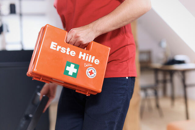 Mann trägt Erste-Hilfe-Koffer